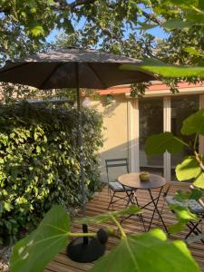 a patio with an umbrella and a table and chair at Les Robinsons in Sillans-la Cascade
