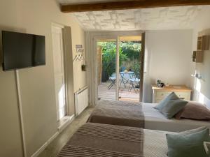 a bedroom with a bed and a tv on a wall at Les Robinsons in Sillans-la Cascade