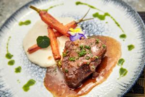 a plate of food with meat and carrots on it at Mila Malia Suites in Malia