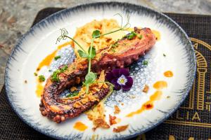 a plate of food with meat and vegetables on it at Mila Malia Suites in Malia