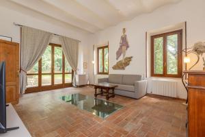 a living room with a couch and a table at Le Querciolaie with Geothermal Pool - by PosarelliVillas in Monteverdi Marittimo