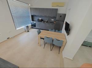 a kitchen with a wooden table and blue chairs at Green Galini Villa Pelion - the small unit in Platanidia