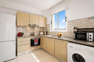 a kitchen with a washing machine and a washer at Apartment El Breeze in Paralimni