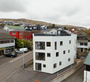 a white building in a city with a street at Á Varða Apartments in Tórshavn