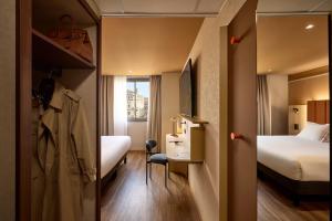 a small room with two beds and a desk and a bed at You Hotel de France Valence - Handwritten Collection in Valence +80 photos