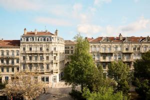 a group of buildings with trees in front of them at You Hotel de France Valence - Handwritten Collection in Valence