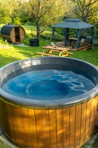 a large hot tub in a yard with a picnic table at Jurta pod Blaníkem s wellnes in Chotýšany