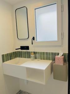 a bathroom with a white sink and a mirror at La Maison Kerguelen - Suite in Quimper