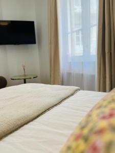 a bedroom with a bed and a window and a table at La Maison Kerguelen - Suite in Quimper +9 photos