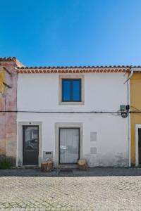a white building with two doors and a window at Pied-a-Terre Tomar in Tomar +16 photos
