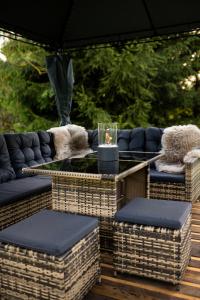a patio with wicker chairs and a table with a candle at Jurta pod Blaníkem s wellnes in Chotýšany