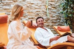 a man and a woman sitting at a table at Hotel Jagdhaus Monzabon in Lech am Arlberg +39 photos