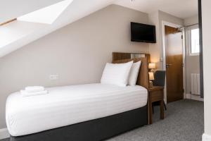 a bedroom with a bed and a tv on the wall at Coach House Accommodation - Room 6 in Carrick on Shannon