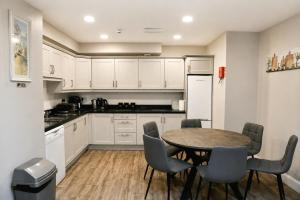 a kitchen with white cabinets and a table and chairs at Coach House Accommodation - Room 6 in Carrick on Shannon
