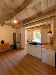 a kitchen with a refrigerator and a counter top at Le pavillon des sœurs in Fontenille