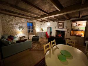 a living room with a table and a couch at Le pavillon des sœurs in Fontenille