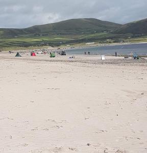 a beach with a group of people flying a kite at The Old Creamery Ventry in Ventry
