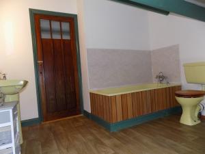 a bathroom with a wooden tub and a toilet at The Old Creamery Ventry in Ventry