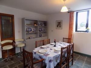 a dining room with a table with chairs and a window at The Old Creamery Ventry in Ventry +11 photos