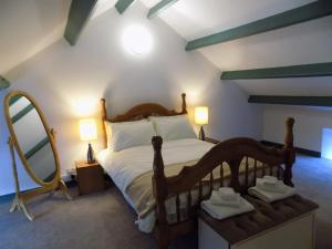 a bedroom with a bed with two lamps and a mirror at The Old Creamery Ventry in Ventry