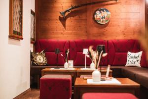 a living room with a red couch and two tables at Hotel Jagdhaus Monzabon in Lech am Arlberg