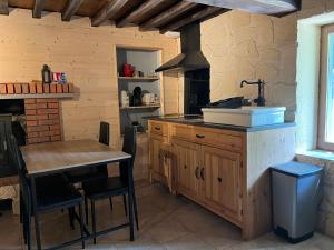 a kitchen with a table and a sink and a stove at Gîte des vergnioux in Ayat-sur-Sioule