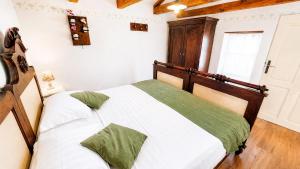 a bedroom with a bed with white sheets and green pillows at Villa Nostalgia - with private heated pool, jacuzzi and sauna in Koper +89 photos