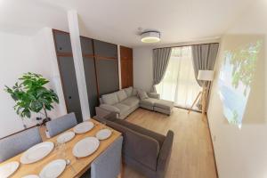 a living room with a table and a couch at Kokura Family House, 10 Min to Station, 2 Parking, 4 Bed Room in Kitakyushu