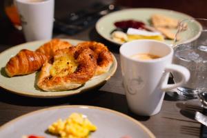 a table with plates of food and a cup of coffee at Frich`s Hotel Surnadal in Surnadal