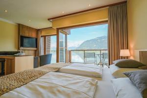 a bedroom with two beds and a large window at Seevilla Freiberg in Zell am See