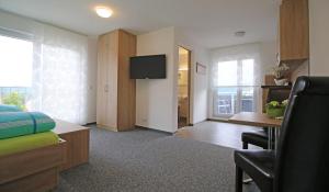 a bedroom with a bed and a desk and a television at Apartments Am Grafenberg in Grafenberg +8 photos