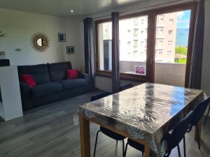 a living room with a table and a couch at Gambetta Insolite in Chambéry