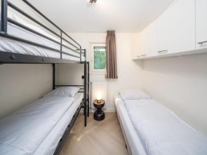 two bunk beds in a room with a window at Veluwepark de Bosgraaf in Apeldoorn +29 photos
