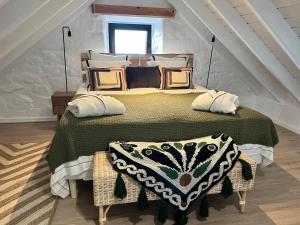 a bedroom with a bed with a green comforter and pillows at Casa do Encanto in Terra Alta