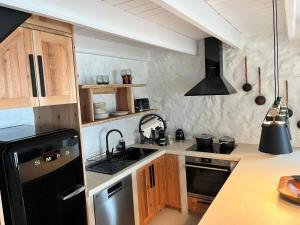 a kitchen with a black refrigerator and wooden cabinets at Casa do Encanto in Terra Alta
