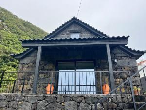 a house with a window on a stone wall at Casa do Encanto in Terra Alta