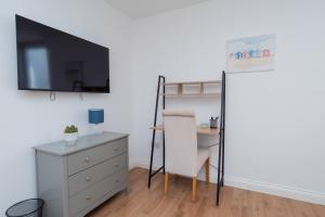 a room with a desk and a chair and a tv at 4 Bed Contractor Apartment with Parking Central Banbury in Banbury