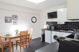 a kitchen and dining room with a table and chairs at 4 Bed Contractor Apartment with Parking Central Banbury in Banbury