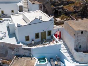 an aerial view of a white house with a red door at Palm Tree Hill in Oia