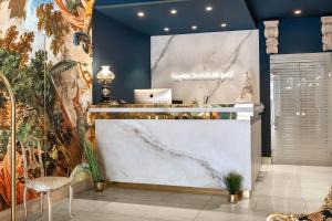 a lobby with a counter with a laptop on it at Hotel Regina in Caserta