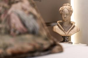 a statue of a woman sitting on a table at Hotel Regina in Caserta +70 photos