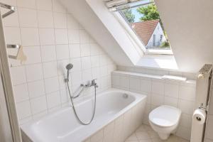 a bathroom with a bath tub and a toilet at Ferienhaus zum Kranichblick ideal für Familien gern mit Hund in Garz +14 photos
