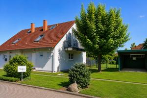 a white house with a red roof and a tree at Ferienhaus zum Kranichblick ideal für Familien gern mit Hund in Garz