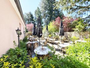 a patio with tables and chairs and umbrellas at Hotel Casa Borghese in Senningerberg