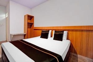 a bedroom with a large white bed with black pillows at Collection O Bwalk Hotel Malang in Malang