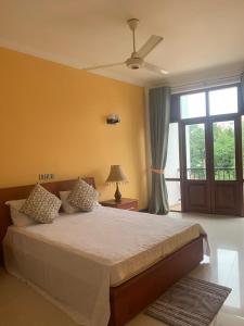 a bedroom with a large bed and a window at Deepa Thamel House in Cotta Road Railroad Station