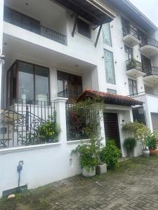 a white building with potted plants in front of it at Deepa Thamel House in Cotta Road Railroad Station