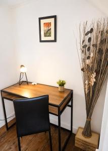 a desk with a chair and a vase of flowers at LE MATIN CALME - Charme ancien - Vue canal in Dole +25 photos