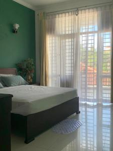 a bedroom with a bed and a large window at Deepa Thamel House in Cotta Road Railroad Station +8 photos