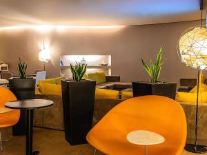 a living room with yellow chairs and a couch at Novotel Setubal in Setúbal